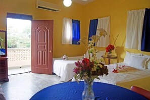 Ein Hotelzimmer mit zwei Betten, einem Balkon und einem Tisch mit Blumen.