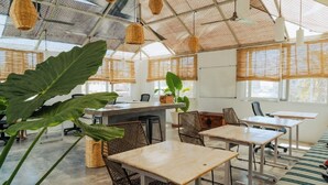 A modern interior with a high ceiling, natural light, and a mix of seating arrangements. - Outsite Todos Santos - Work, Connect, Explore (Todos Santos)