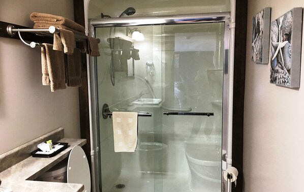 A modern bathroom with a glass shower enclosure, a toilet, and a sink. - Admirals Bed and Breakfast (Twillingate)