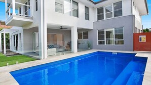 A modern two-story house with a swimming pool, large windows, and a covered patio area. - CHATEAU CALIZA - The Vintage Holiday Houses (POKOLBIN)