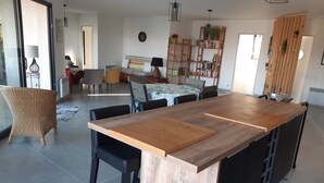 Une cuisine spacieuse avec un îlot central, des chaises noires et une table à manger.