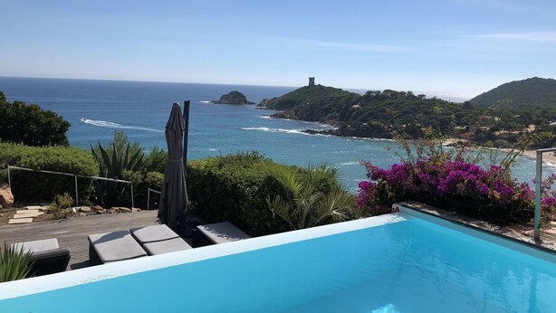 Ein Pool mit Blick auf das Meer und die Hügel.