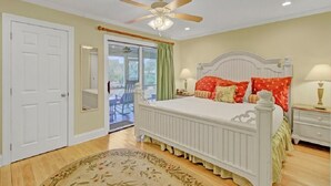 A bedroom with a white bed, a ceiling fan, and a view to the outside. - Award-Winning Resort Amenities | Mariners Walk 4C (Isle of Palms)