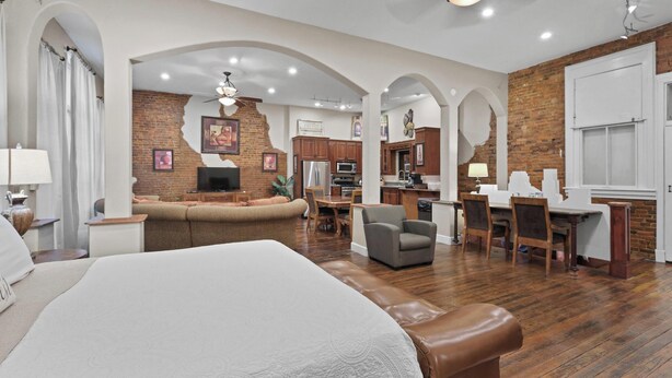 A spacious hotel room with a large bed, a seating area, a kitchenette, and a dining area. - Crossroads Loft:  Steps from Rt. 66 & Carthage Square (Carthage)