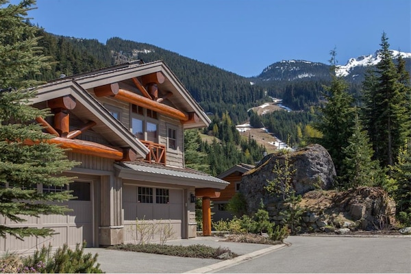 Exterior of our home in the Spring. Peak to Creek ski run in background