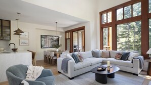 Un salon moderne avec un grand canapé, une table basse et un coin repas comprenant des chaises et une table.