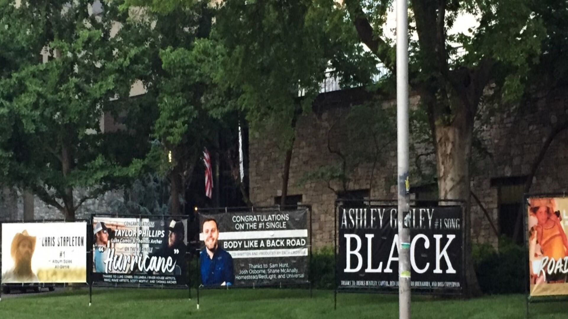 A row of outdoor billboards with various advertisements.