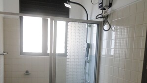 Ett badrum med en dusch som är avskärmad med glasväggar, en toalett och ett handfat.