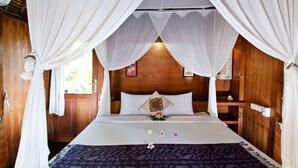 A room with a bed, wooden walls, and a canopy bed. - Lumbung Bali Huts (Lembongan Island)