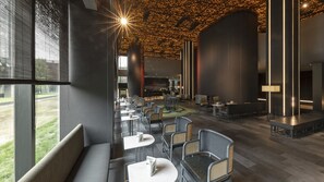 A modern interior with a long dining area, seating arrangements, and a bar area.