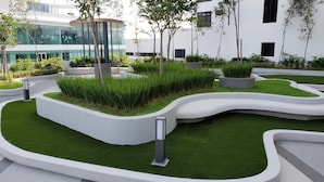 A landscaped outdoor area with modern architecture in the background.