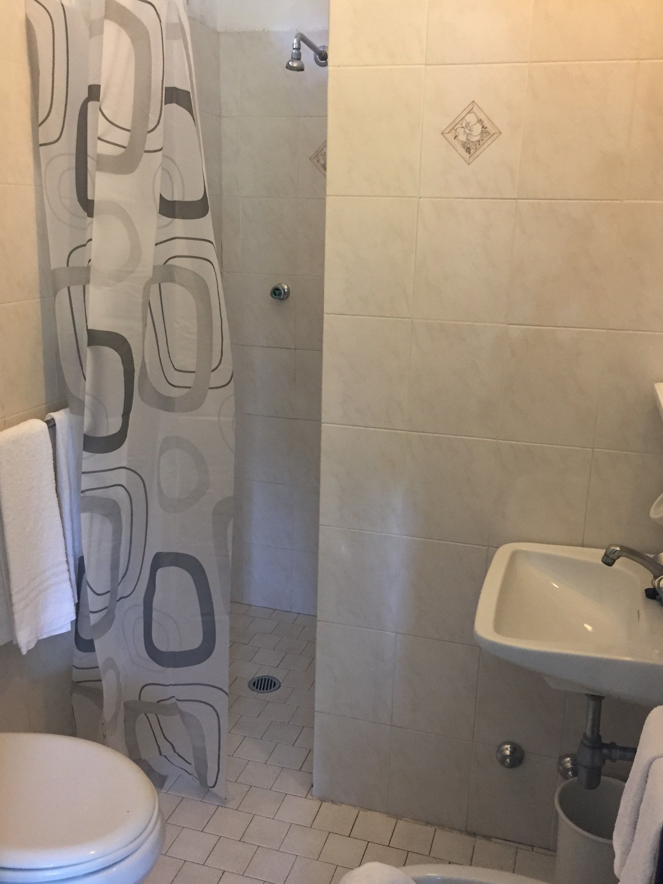 Ein Badezimmer mit Dusche, Toilette und Waschbecken.