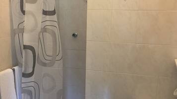 Ein Badezimmer mit Dusche, Toilette und Waschbecken.