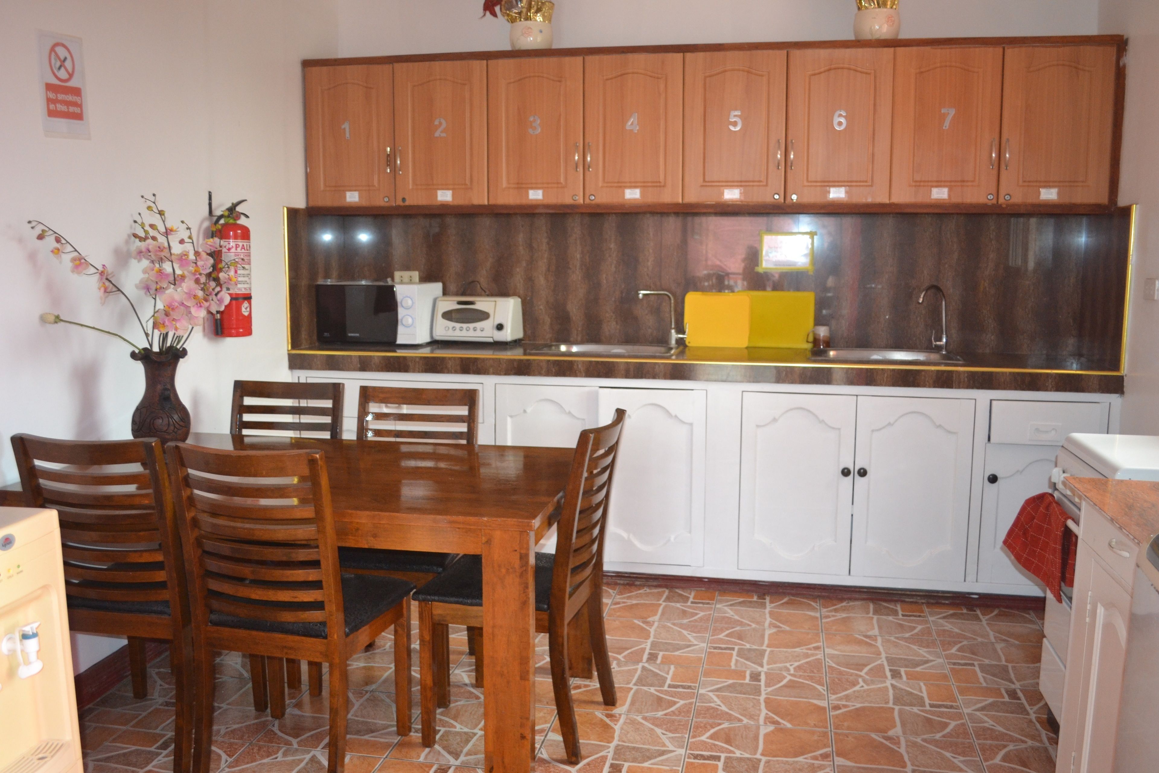 A kitchen with wooden cabinets, a microwave, a toaster, and a sink.
