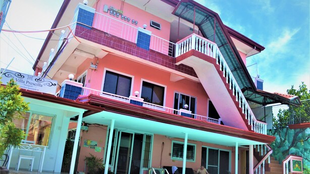 A multi-story building with balconies, a swimming pool, and a covered outdoor area.