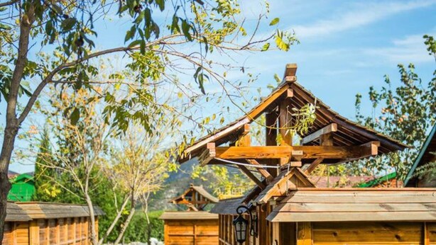 Eine Holzhütte mit geneigtem Dach und einer kleinen Veranda.