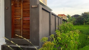 A building with a wooden door labeled "FABIA" and a concrete wall. - Fabia Villas (Seminyak)