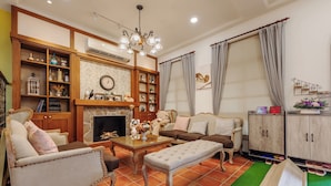 A cozy living room with a fireplace, wooden shelves, and a comfortable seating area. - Southern France (Checheng)
