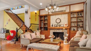 A spacious living room with a staircase, multiple seating areas, and a fireplace. - Southern France (Checheng)