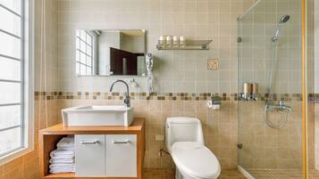 A bathroom with a sink, toilet, and shower.
