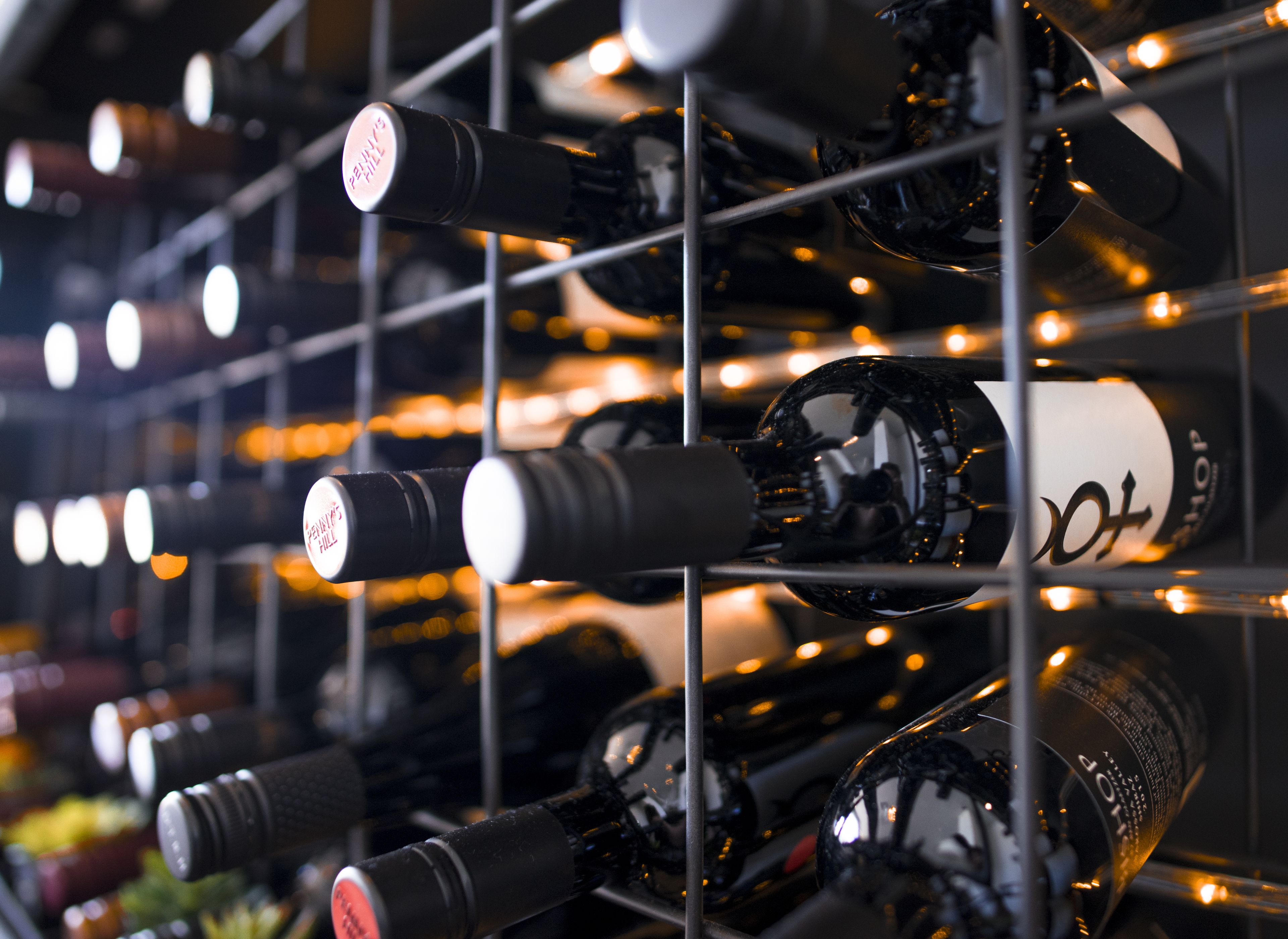 A wine rack with multiple bottles, some with labels visible.