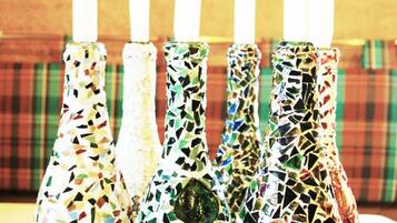 Four mosaic-patterned candle holders with white candles.