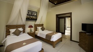 Habitación de hotel con dos camas, televisión y vista del paisaje urbano a través de la ventana.
