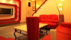 Una sala de estar moderna con sofás rojos, un televisor de pantalla plana y una escalera.