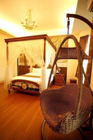 A four-poster bed with a canopy, a wicker hanging chair, and a chandelier. - Bear Castle Homestay (Hualien City)