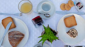 Une table de petit-déjeuner avec divers aliments, des ustensiles et une plante.