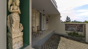 A building with a statue, a door, and a signboard. - Dhanesvara Holistic Villa (Batu)