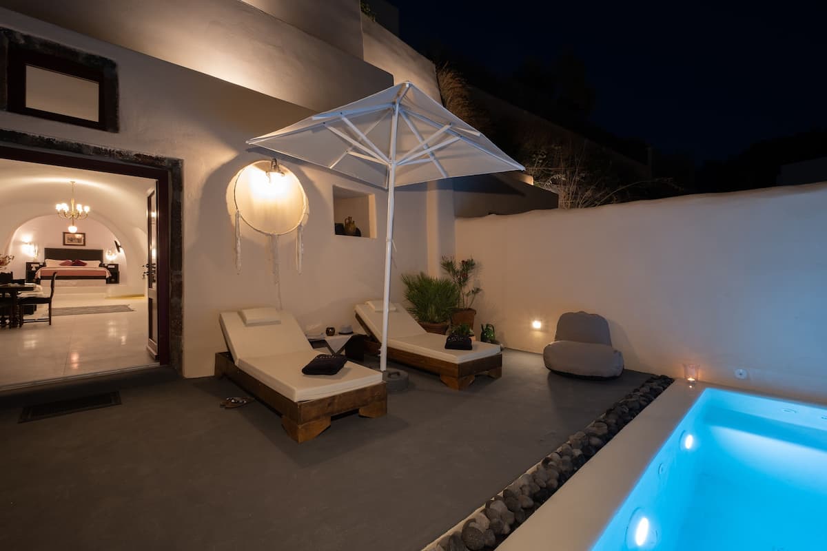 Een modern buitenverblijf met lounge stoelen, een zwembadje en een sfeervolle verlichting.
