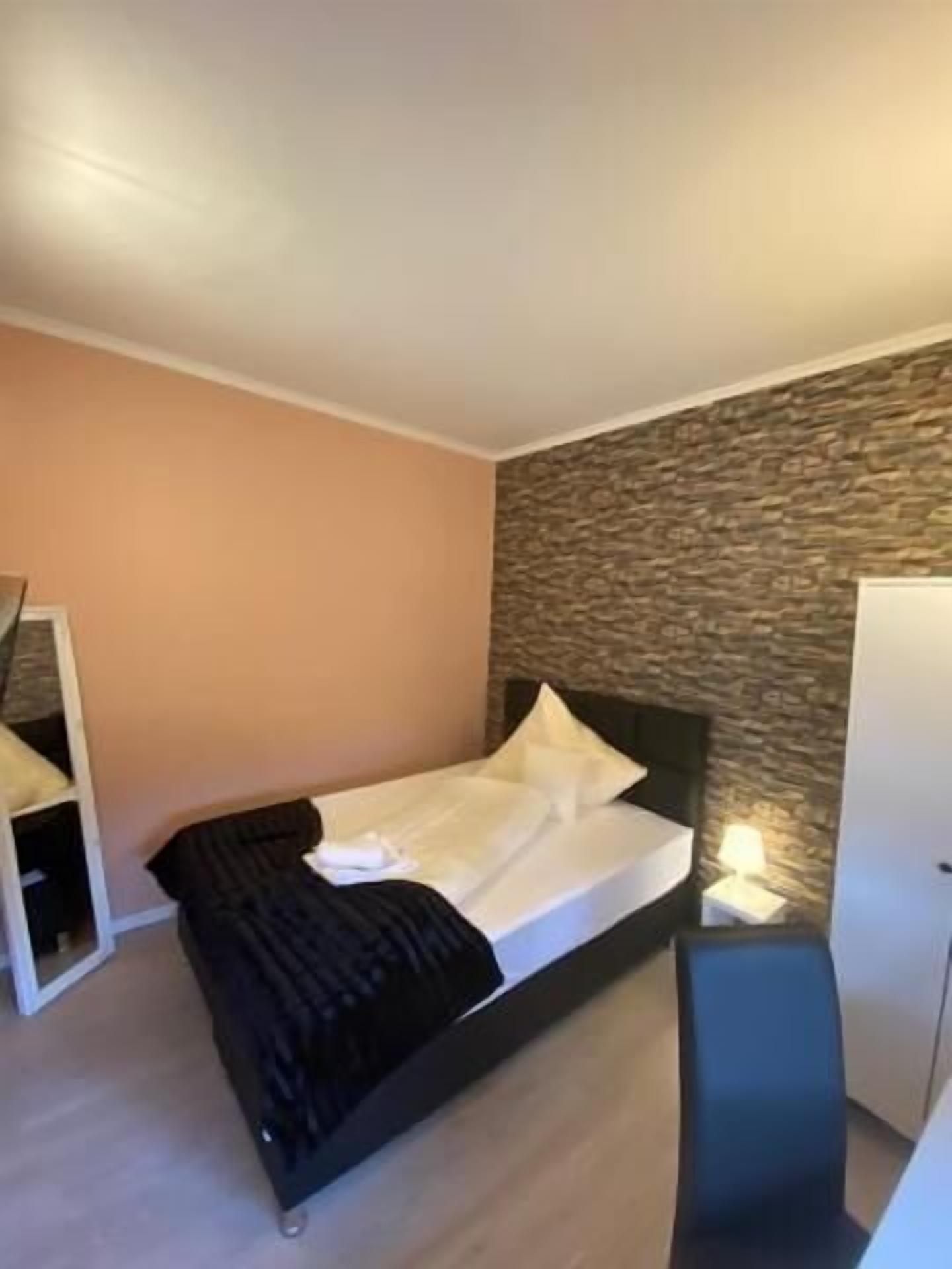 Una camera da letto moderna con un letto, una scrivania e un'armadio.