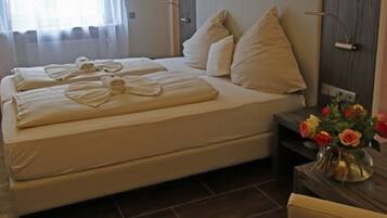 Un dormitorio moderno con una cama grande, dos mesitas de noche y un florero.