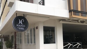 A modern building with a sign for 'NAPAS RESIDENCE' and a number '65' on the facade. - Napas Residence (Hat Yai)