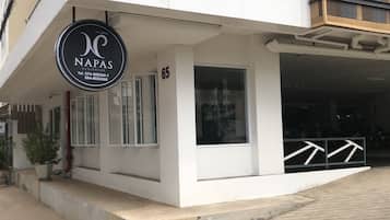 A modern building with a sign for 'NAPAS RESIDENCE' and a number '65' on the facade.