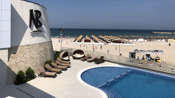 A pool area with lounge chairs and a view of the beach. - Hotel New Belvedere (Mangalia)