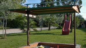 A playground with a slide and sand play area.