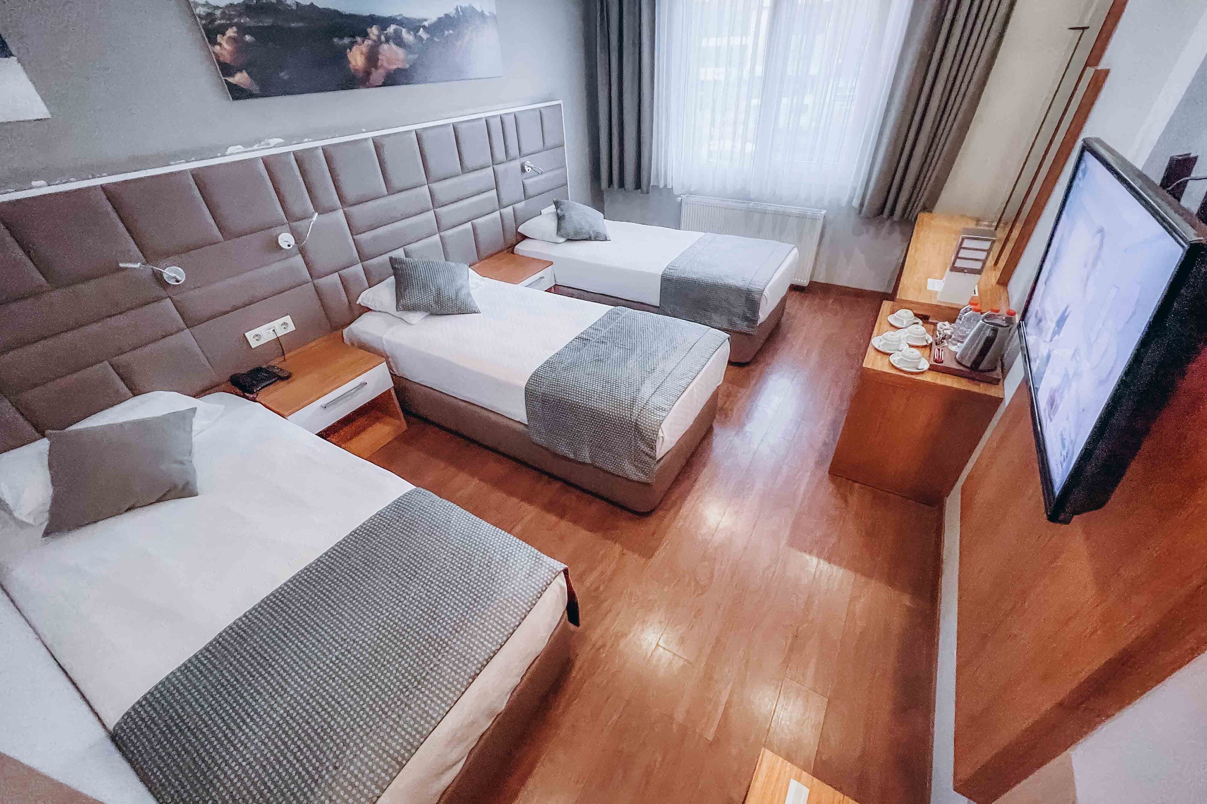 A hotel room with two beds, a television, and a small table with a coffee maker.
