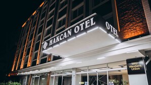 The exterior of Hakcan Hotel with a modern facade, large glass windows, and a sign for Western Union. - Hakcan Hotel (Izmir)