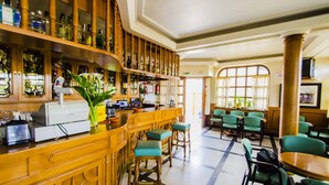 A bar area with wooden shelves, bar stools, and a cash register. - Hostal Don Suero de Quiñones (Hospital de Orbigo)