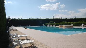 Una piscina al aire libre de temporada, camas de piscina gratis