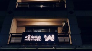 A building with a sign that reads "Wam" and "Wam Cafe." - Warm & Cozy Inn (Hengchun)