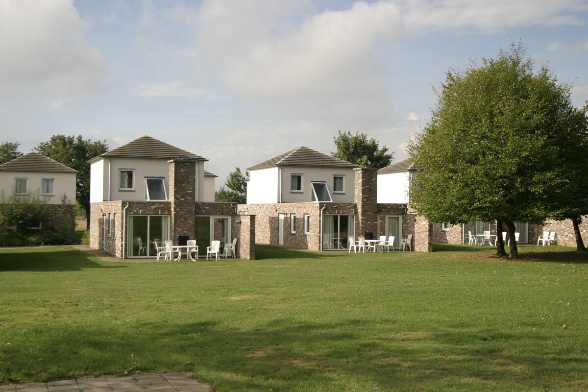 Een rij moderne huizen met een gazon ervoor.