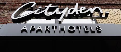 Ein Gebäude mit einem Schild, auf dem 'Cityden APARTHOTELS' steht.