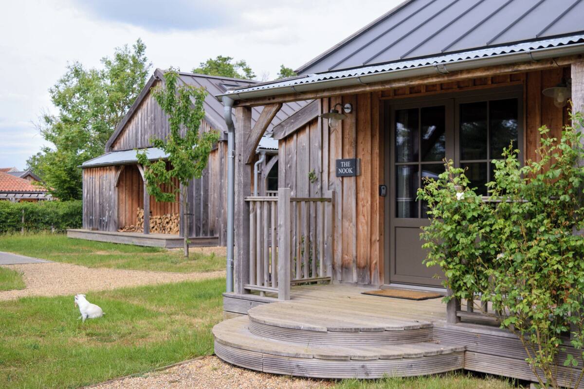 A rustic wooden building with a porch and a sign that reads "The Nook."