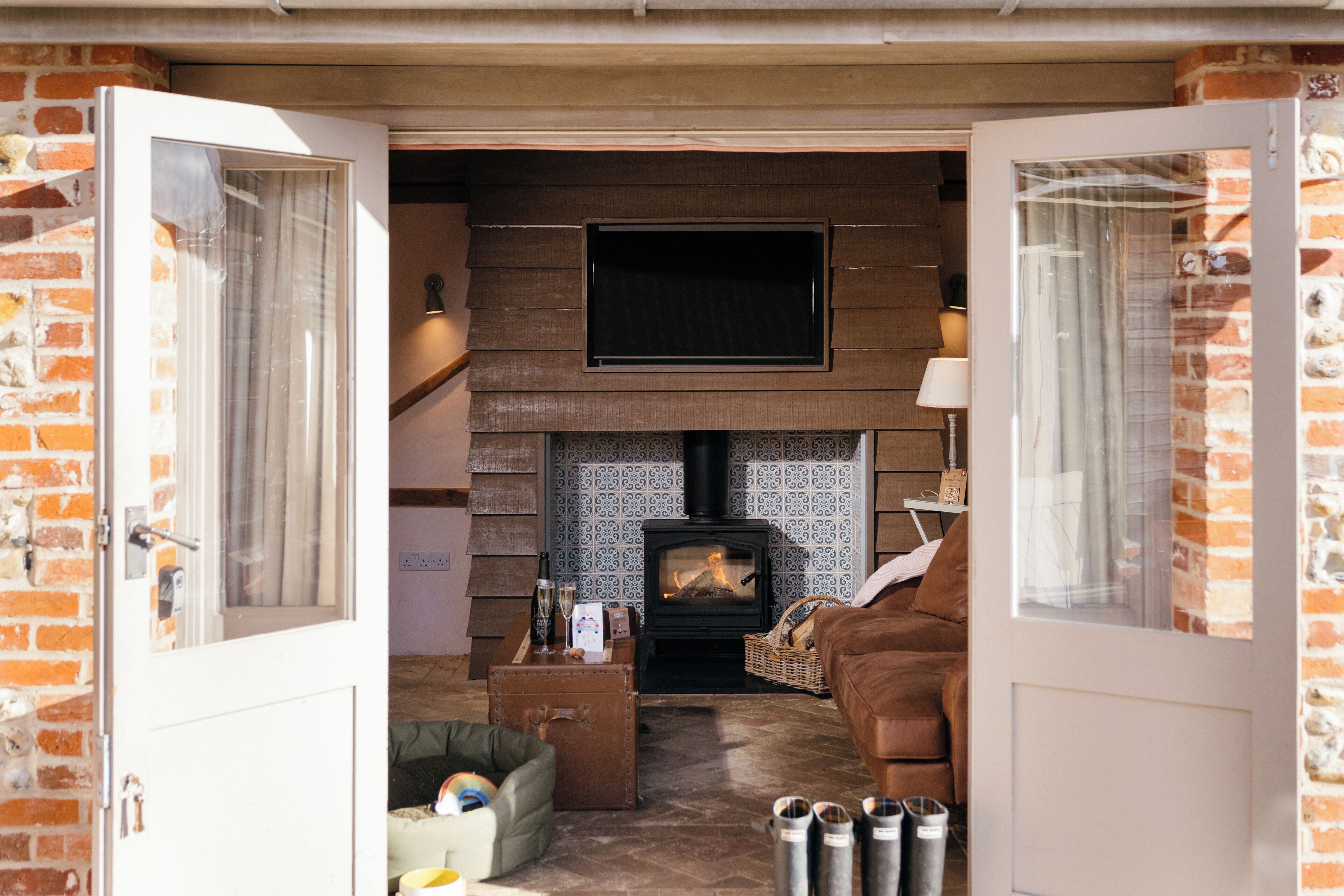 A cozy living room with a fireplace, a television, and a comfortable couch.