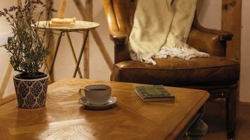A wooden table with a cup, a book, and a potted plant.
