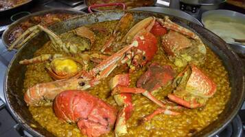 Una olla grande con guiso de mariscos, incluyendo cangrejos y maíz.