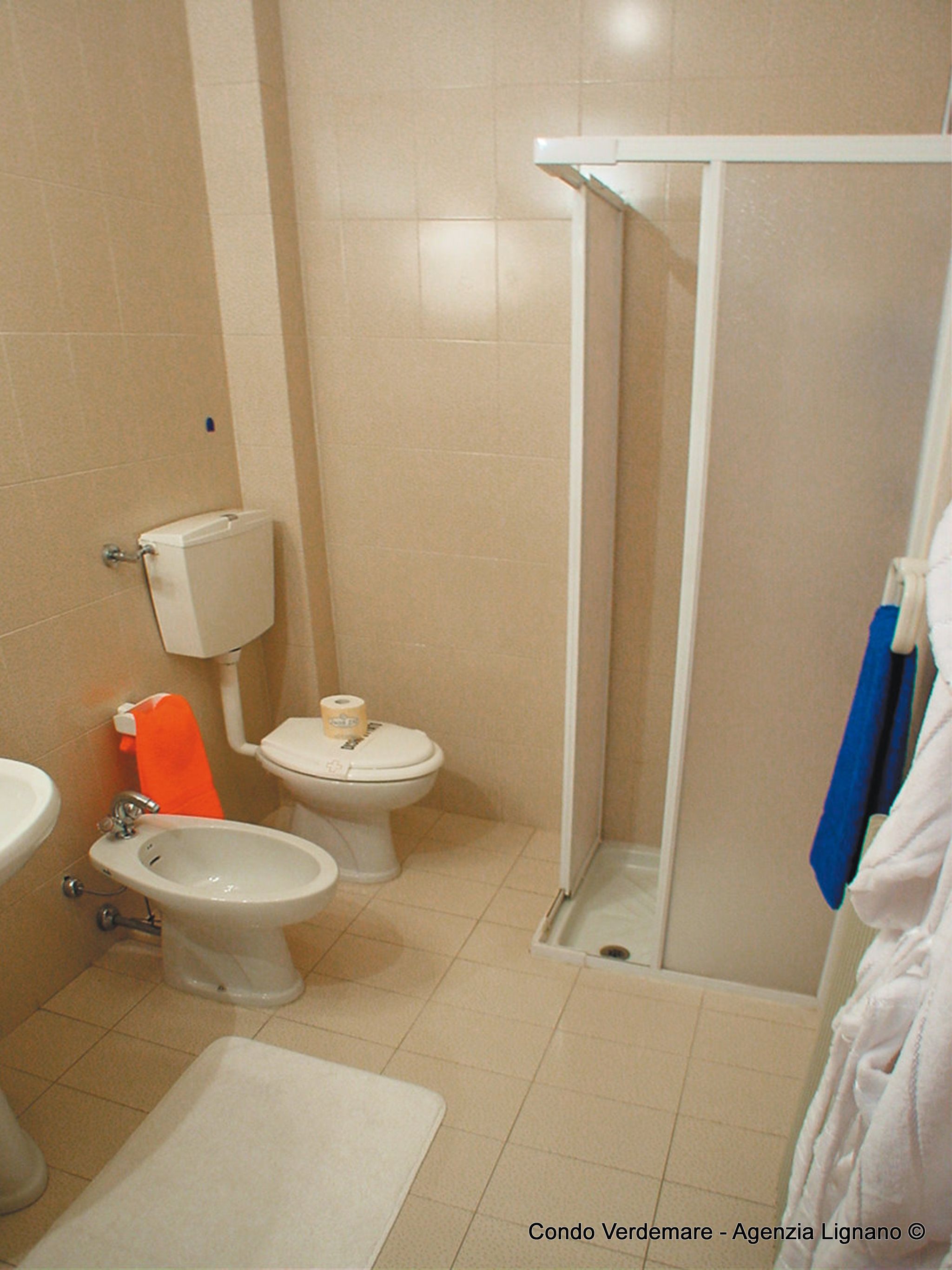 Un baño con inodoro, bidé y lavamanos.
